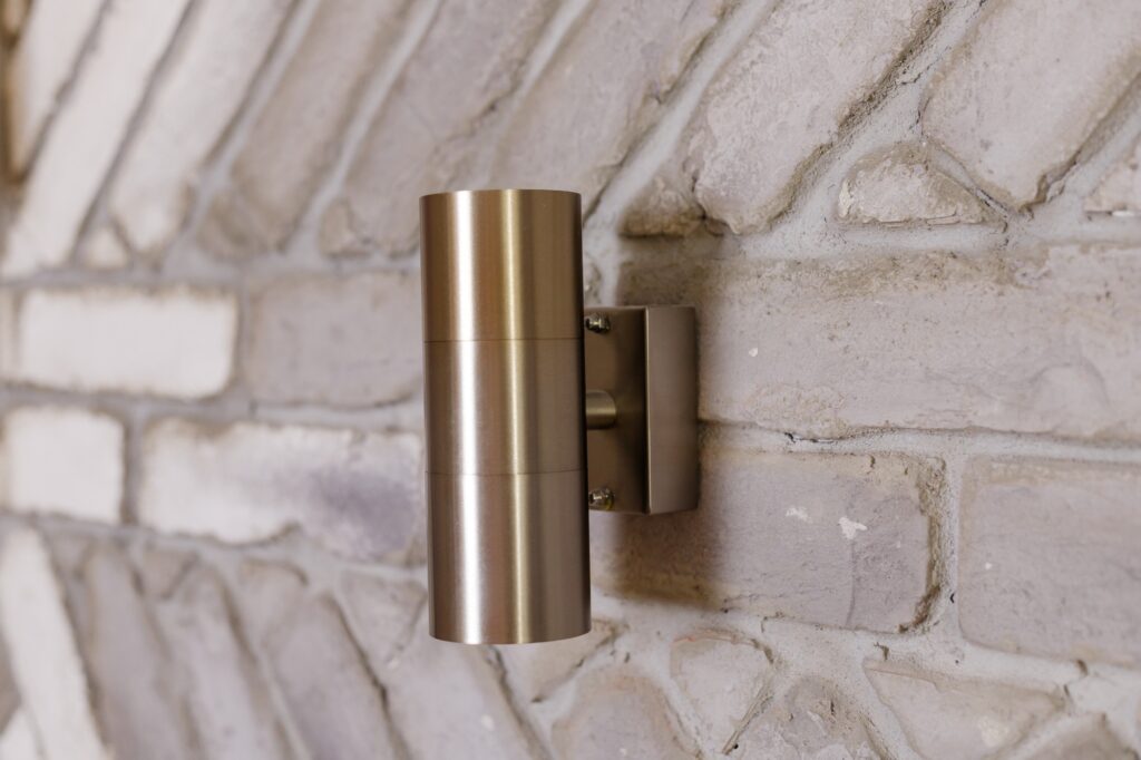 Loft metal wall sconce on brick wall. Tube- shaped wall light